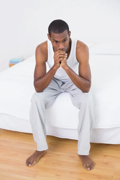 Pensativo jovem afro homem sentado na cama — Fotografia de Stock