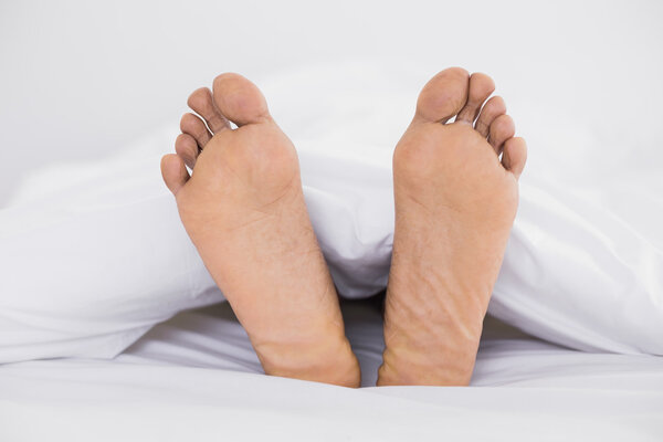 Close up of bare feet in bed