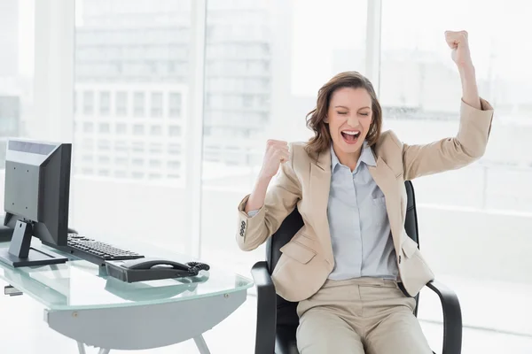 Affärskvinna jublar med händerna upp i office — Stockfoto