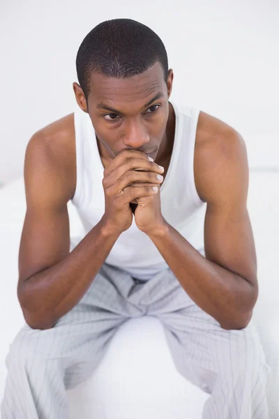 Nachdenklicher Afro-Mann sitzt auf Bett — Stockfoto