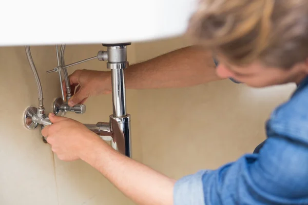 Plumber repairing washbasin drain at bathroom — Stock Photo, Image