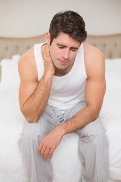 Retrato do homem que sofre de dor de pescoço na cama — Fotografia de Stock