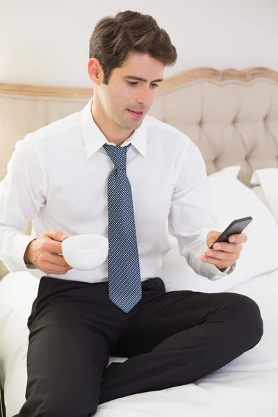 Goed geklede man van het tekstoverseinen in bed — Stockfoto