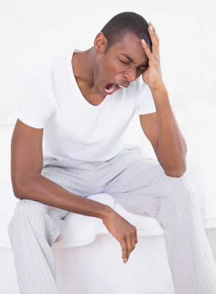 Joven hombre afro bostezando en la cama en casa — Foto de Stock