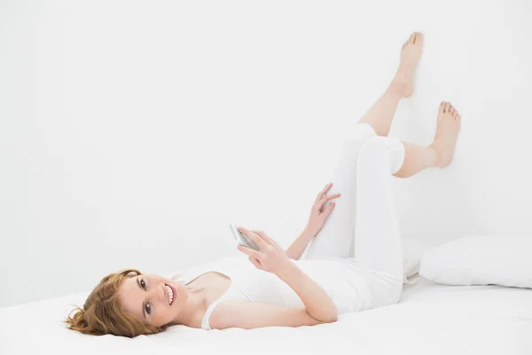 Portret miłej kobiety z telefonu komórkowego w łóżku — Zdjęcie stockowe