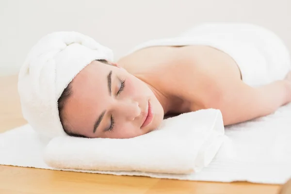 Beautiful woman with eyes closed on towel at beauty spa — Stock Photo, Image