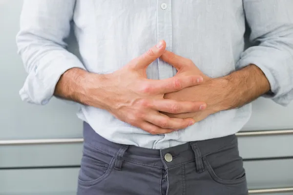 Mitten av en man som lider av magsmärtor — Stockfoto