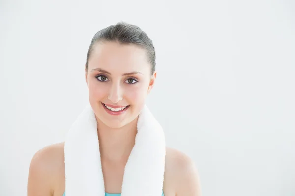 Fit woman with towel around neck against wall — Stock Photo, Image