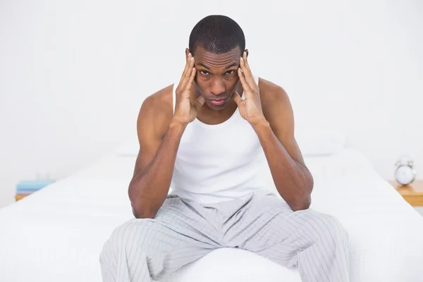 Afro homem que sofre de dor de cabeça na cama — Fotografia de Stock