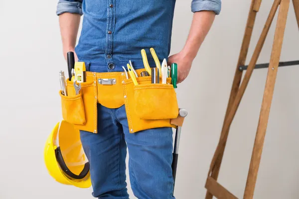 Bir tamirciyle toolbelt ve kask ile orta kısmında — Stok fotoğraf