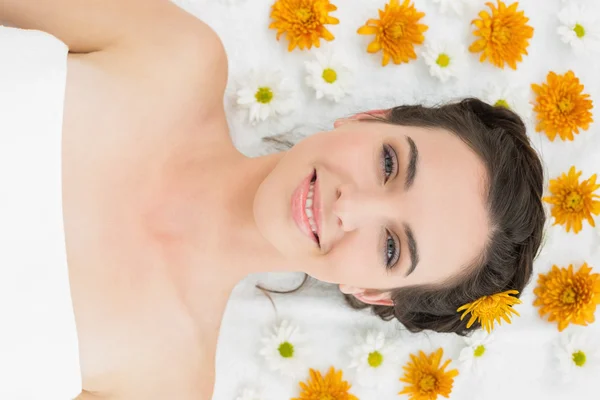 Schöne junge Frau mit Blumen im Schönheitssalon — Stockfoto