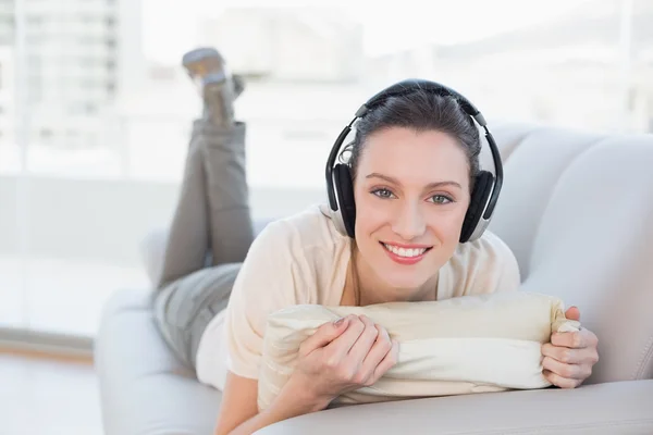 Relaxé décontracté jeune femme appréciant la musique sur canapé — Photo