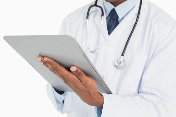 Close up mid section of a male doctor writing on clipboard — Stock Photo, Image