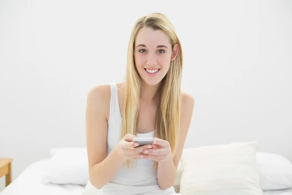 Belle femme blonde regardant choquée par son smartphone — Photo