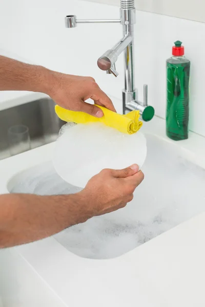 Mid section of man doing the dishes at kitchen sink — Stock Photo, Image