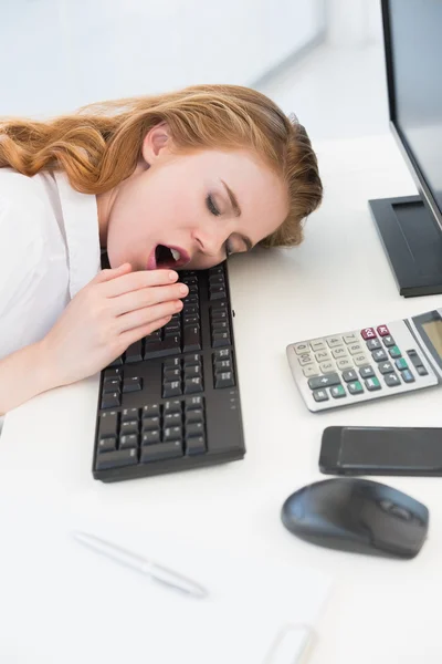 Empresária adormecida bocejando no teclado no escritório — Fotografia de Stock