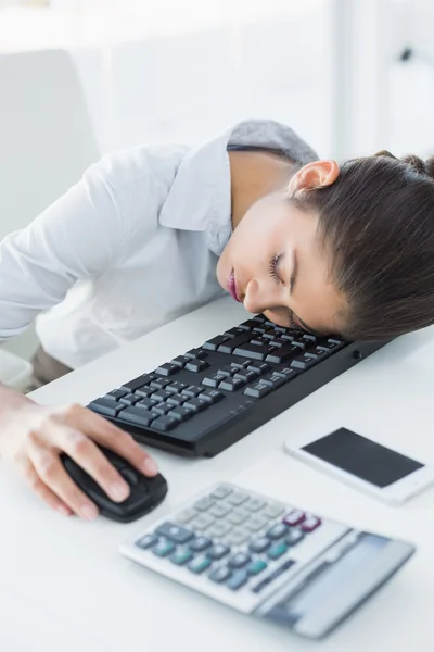 Affärskvinna vilar huvudet på tangentbordet i office — Stockfoto