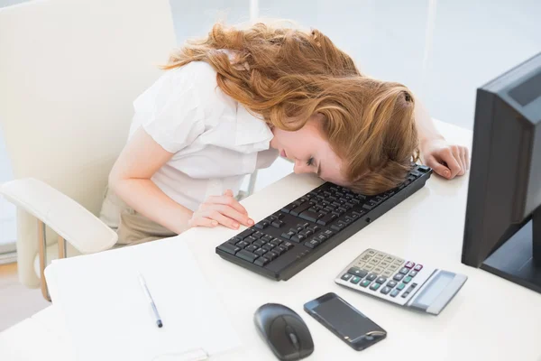 Geschäftsfrau ruht sich im Büro kopfüber auf Tastatur aus — Stockfoto