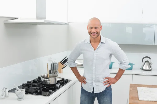 Mutfak yanı sıra genç adam gülümseyerek portresi soba — Stok fotoğraf