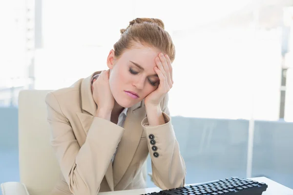 Affärskvinna med nacksmärta på skrivbord — Stockfoto