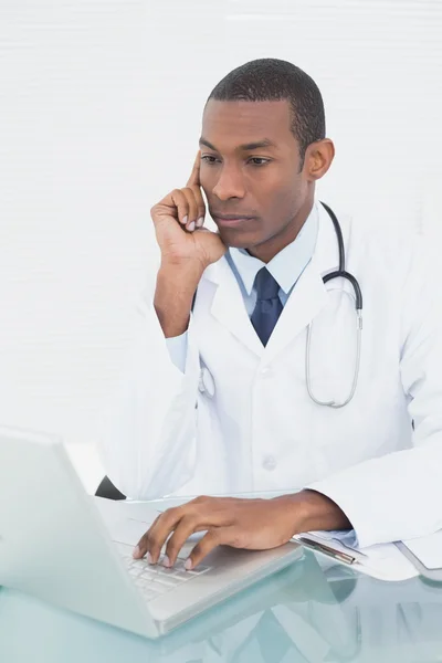 Médecin utilisant un ordinateur portable au bureau médical — Photo