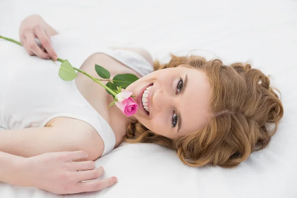 Glad kvinna med mobiltelefon i sängen — Stockfoto