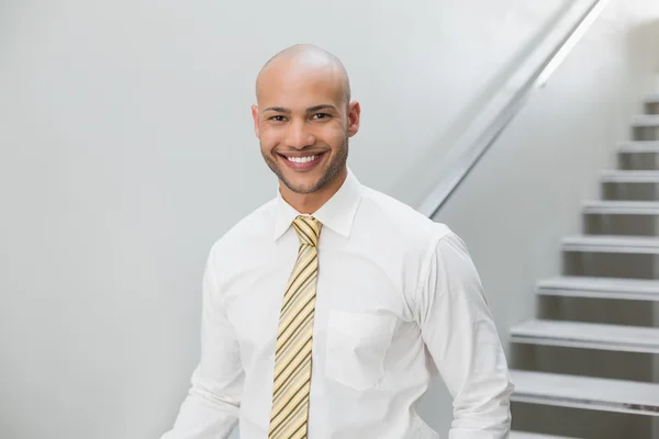 階段に対して立っている笑顔のエレガントなビジネスマン — ストック写真