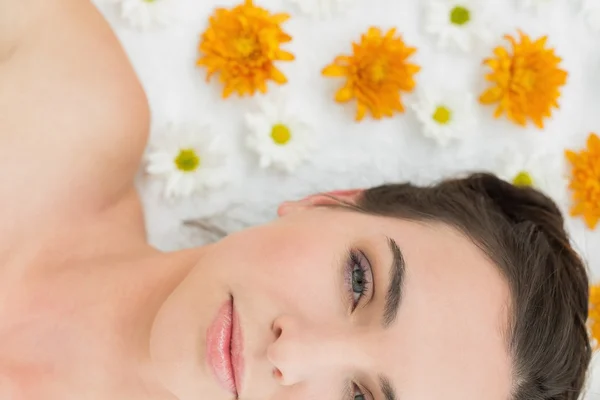 Krásná mladá žena s květinami v salonu krásy — Stock fotografie