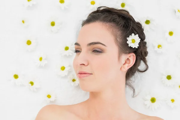 Beautiful young woman with flowers in beauty salon — Stock Photo, Image