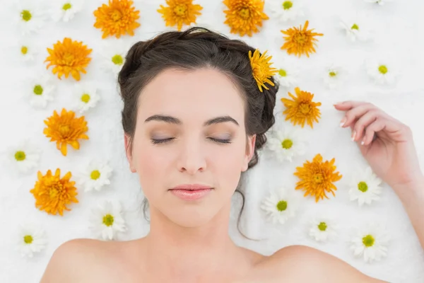 Beautiful woman with eyes closed and flowers in beauty salon — Stock Photo, Image