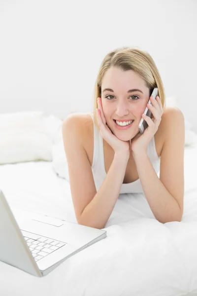 Beautiful blonde woman phoning peacefully lying on her bed — Stock Photo, Image