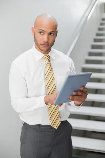 Uomo d'affari con tablet digitale guardando altrove — Foto Stock