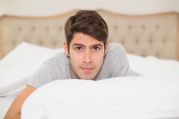 Close up portrait of a smiling man resting in bed — Stock Photo, Image