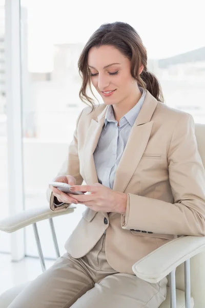 Businesswoman text messaging in office — Stock Photo, Image