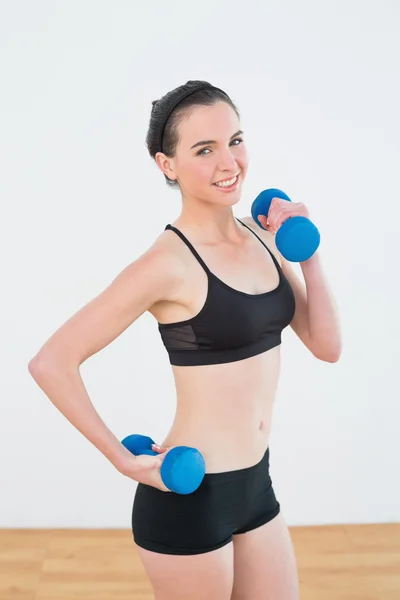 Mulher sorridente com halteres no estúdio de fitness — Fotografia de Stock