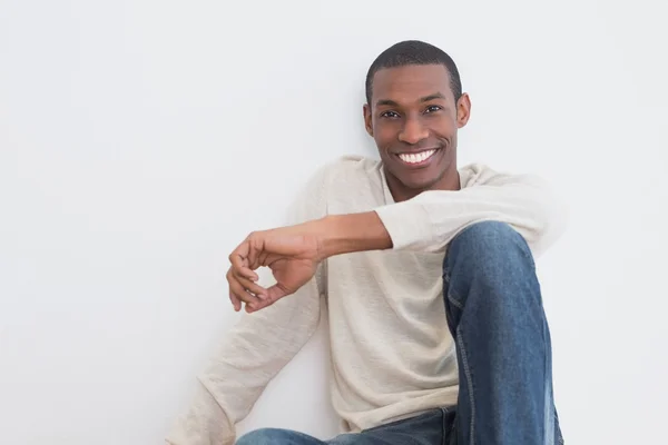 カジュアルなアフロ若い男が壁に座っています。 — ストック写真