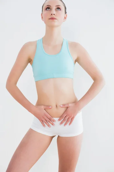 Serious toned woman standing against wall — Stock Photo, Image