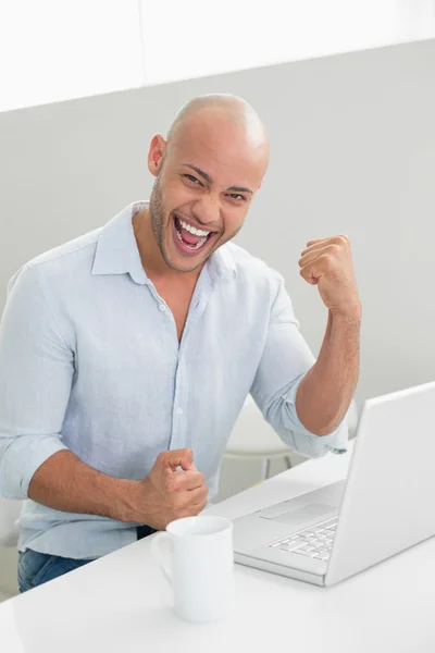 Веселый случайный человек, использующий ноутбук дома — стоковое фото