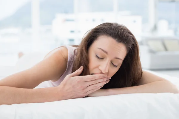 Mujer bostezando con los ojos cerrados en la cama — Foto de Stock