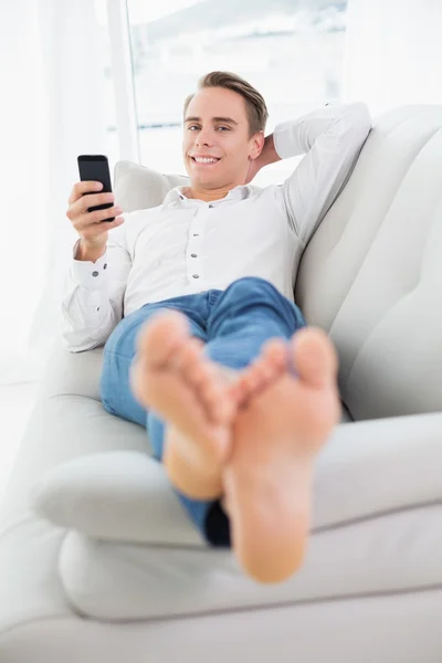 Ontspannen jongeman liggend op de Bank en het Overseinen van de tekst — Stockfoto