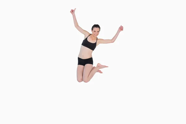 Full length of a sporty young woman jumping — Stock Photo, Image