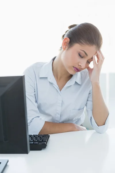 Mujer de negocios que sufre de dolor de cabeza delante de la computadora portátil — Foto de Stock