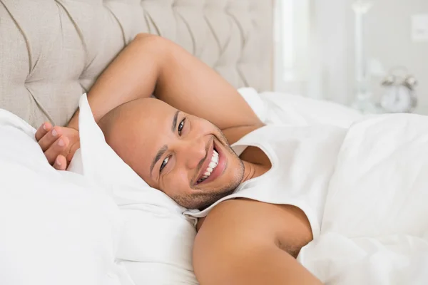 Sonriente joven calvo descansando en la cama —  Fotos de Stock