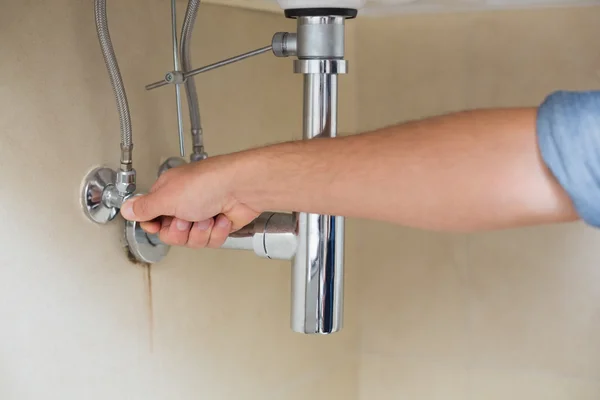 Primer plano de un fontanero reparando lavabo — Foto de Stock