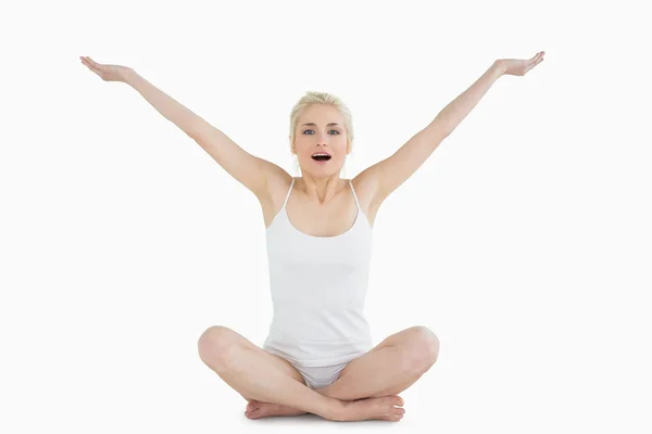 Toned young woman sitting with arms outstretched — Stock Photo, Image