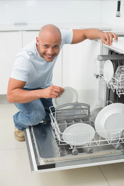 Portrait of smiling man using dish washer in kitchen — Stock Photo, Image