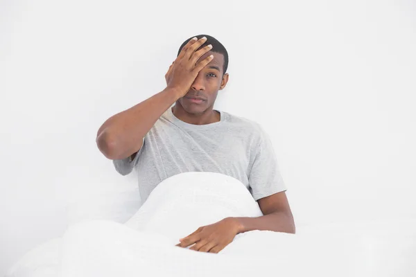 Retrato de homem afro sonolento sentado na cama — Fotografia de Stock