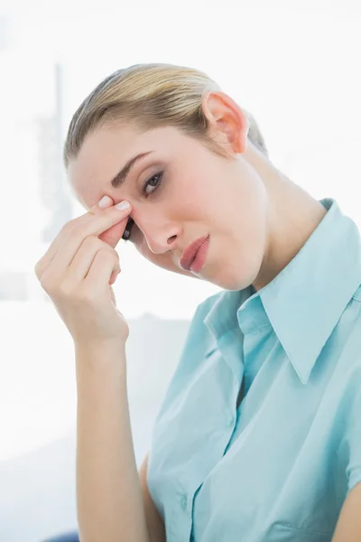 Erschöpfte schicke Geschäftsfrau sitzt mit Kopfschmerzen auf ihrem Drehstuhl — Stockfoto