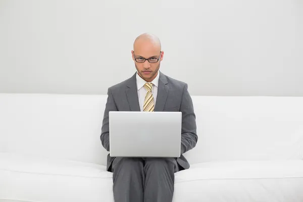 Zakenman met behulp van laptop op de Bank thuis — Stockfoto