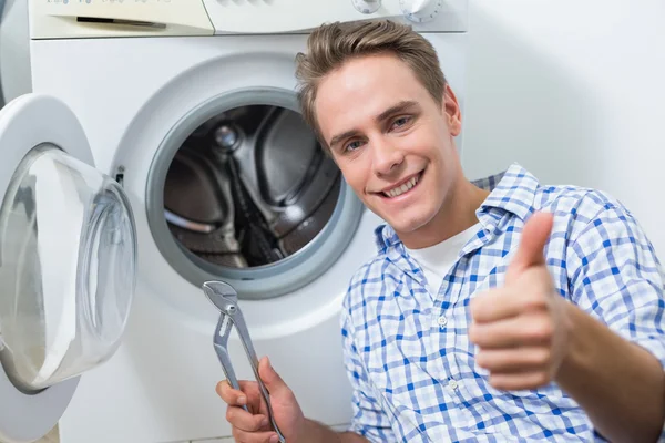 Technicien réparer la machine à laver tout en gestualisant pouces vers le haut — Photo